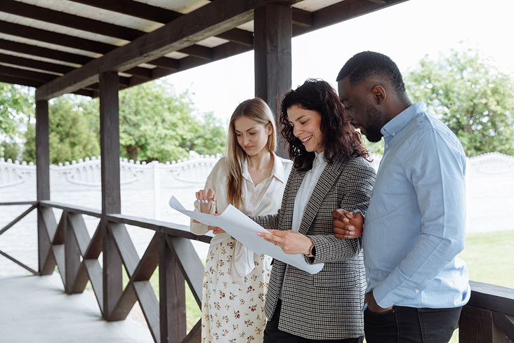 Real estate team reviewing plans on a porch