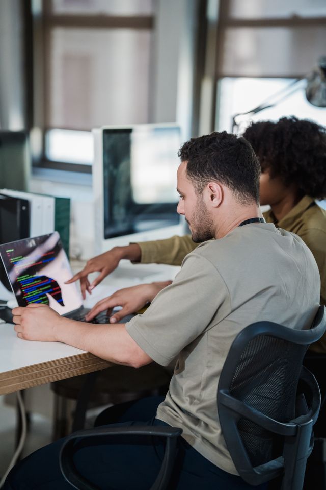 Developer working at a laptop with code on screen